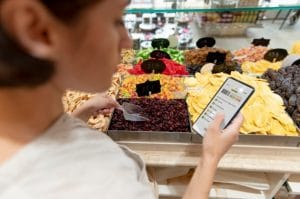 femme-recherchant-differents-goodies-sa-liste-courses-smartphone